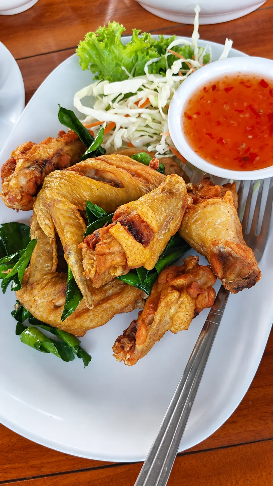 ปีกไก่ทอดสีเหลืองทองพร้อมน้ำจิ้มที่ครัวบ้านวัง