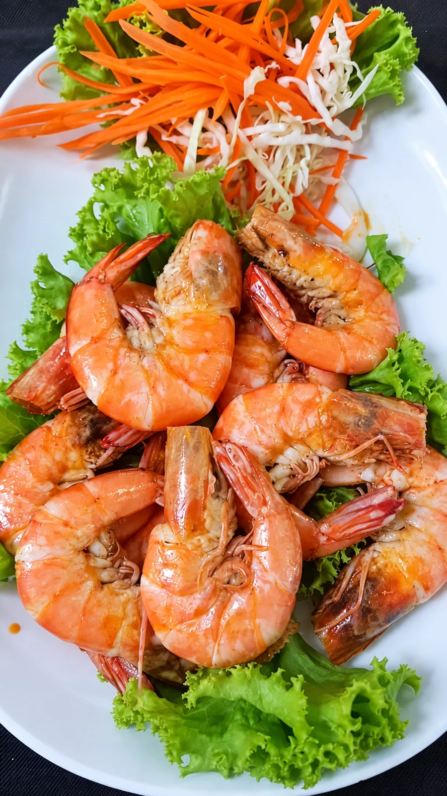 กุ้งสุกสีส้มเรียงบนจานรองด้วยผักกาดหอมที่ครัวบ้านวัง
